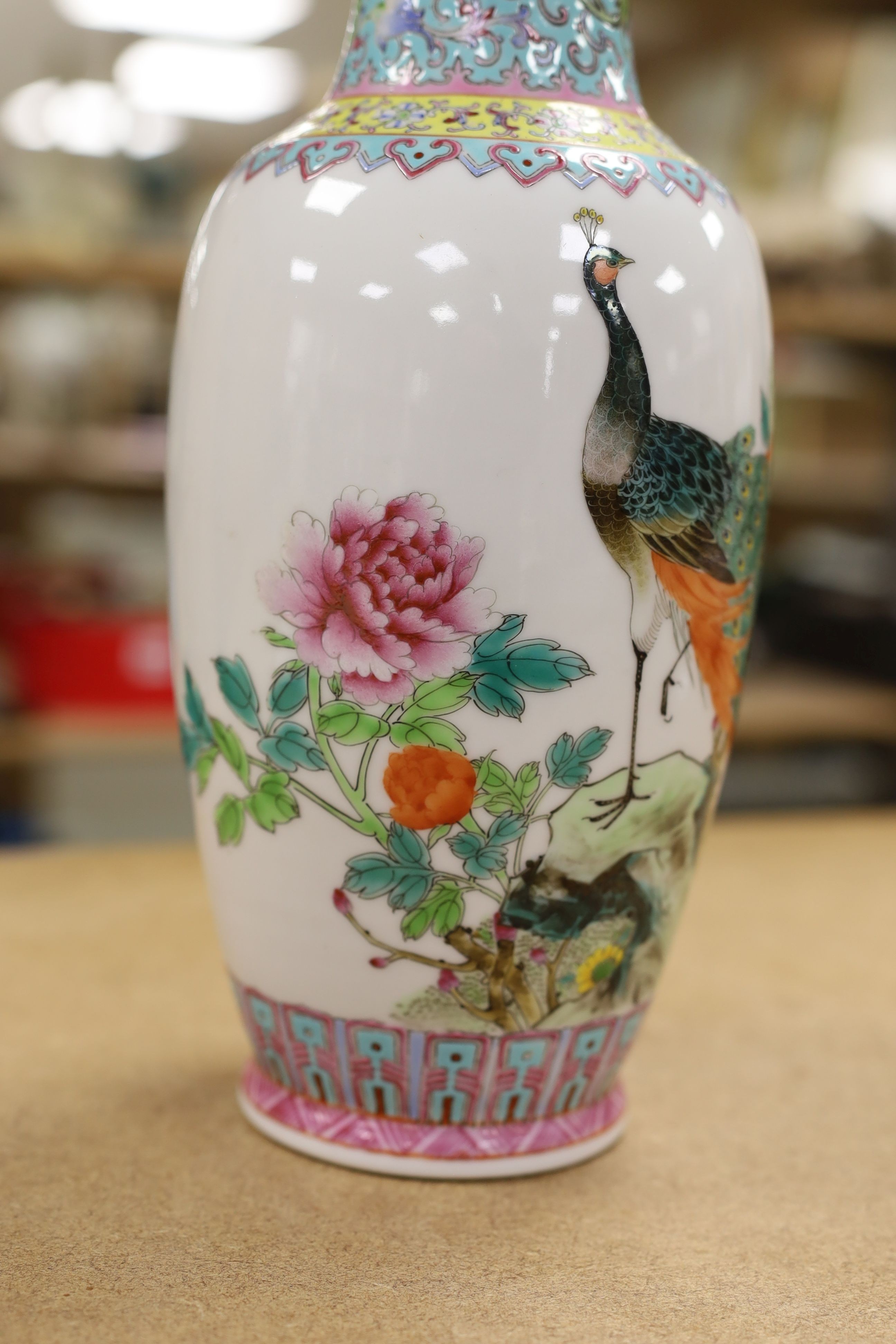 A pair of Chinese famille rose vases decorated with peacocks, 31cm